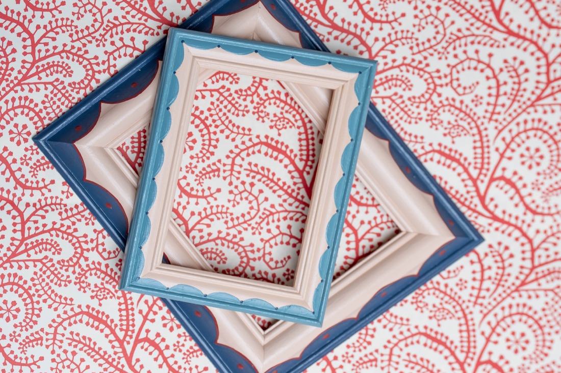 Layered blue and pink hand painted picture frames on patterned paper.